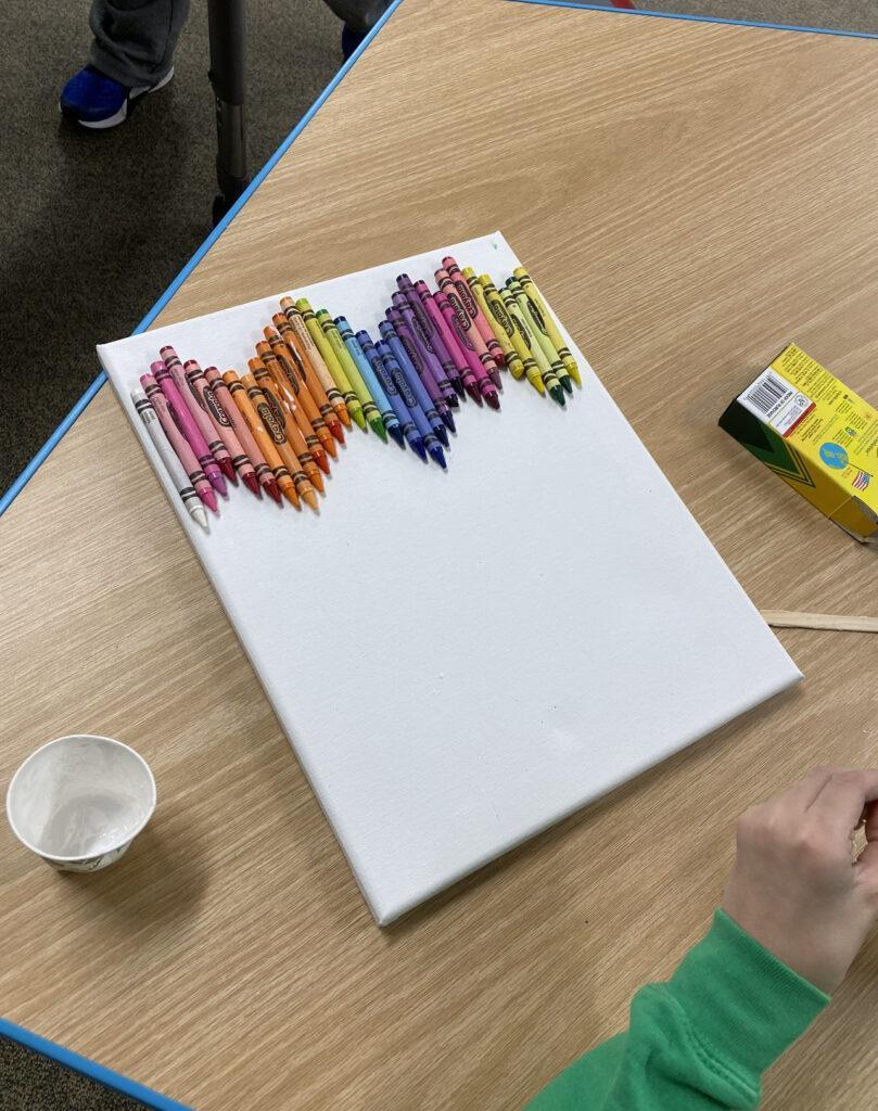 make different color combinations of old crayons at the top of the canvas